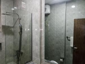 a shower with a glass door in a bathroom at Caritas Inn Igbobi in Lagos