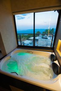 a jacuzzi tub in a room with a window at Villa Real Chalés in Viçosa do Ceará