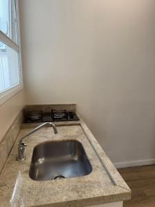 a kitchen counter with a sink and a stove at Açores Flat Design- Próximo ao Gasômetro e Cais Embarcadero in Porto Alegre +36 photos