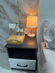 a bedside table with two bottles of water and a lamp at The friendly stay in Male City