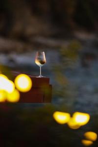 a glass of wine sitting on top of a table at Oniro by Iliria Palace in Himare