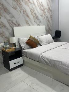 a bedroom with a bed with a nightstand next to it at The friendly stay in Male City
