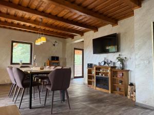 a dining room with a table and chairs and a tv at Serenity Colibița in Colibiţa