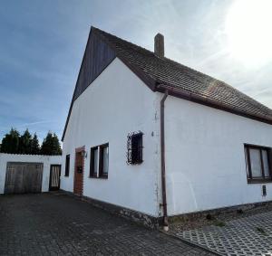 a white building with a black roof at Pension Highway 3 - Preußisch Oldendorf Goethestraße 6 in Preußisch Oldendorf