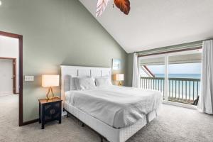 a white bedroom with a bed and a large window at Sun 'n Surf in Inlet Beach