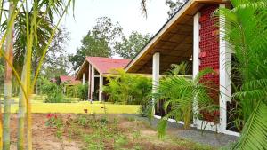 a house with a red and white at The Infinity Pench Resort in Khawāsa