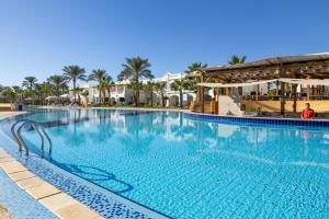 a large swimming pool at a resort with palm trees at Continental Plaza Beach Resort in Sharm El Sheikh