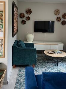 a living room with two blue chairs and a tv at 29 Village Place in Gaborone