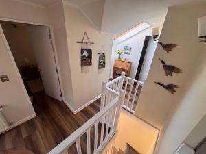 a hallway with stairs and a stair case with birds on the wall at Decher Apartment - Puerto Varas in Puerto Varas