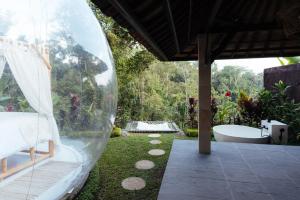 a bathroom with a tub and a yard with a bath tub at Bubble 6 - Romantic Bath Bubble Stay Ubud in Tampaksiring