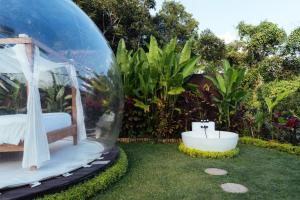 a bedroom in a bubble in a garden at Bubble 6 - Romantic Bath Bubble Stay Ubud in Tampaksiring