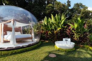 a bed and a bath tub in a garden with a sink at Bubble 6 - Romantic Bath Bubble Stay Ubud in Tampaksiring +13 photos