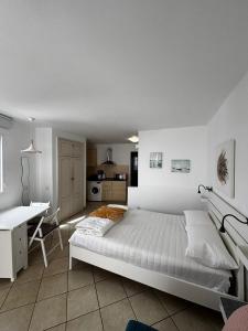 a white bedroom with a bed and a desk at Apartamento Te Miti in Puerto del Carmen +33 photos