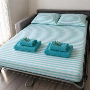 a bed with two blue towels on top of it at Studio Villa Loostic in Martigues