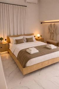 a bedroom with a large bed with two towels on it at 500 sqm Private Garden, Outdoor Kitchen, near Falasarna & Balos Beach in Falasarna