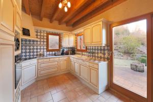 a kitchen with white cabinets and a large window at Chalet la roche du rain in Gérardmer