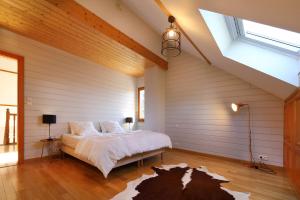 a bedroom with a large bed in a room with wooden floors at Chalet la roche du rain in Gérardmer