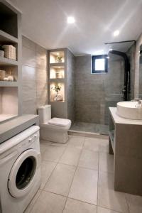 a bathroom with a washing machine and a sink at 500 sqm Private Garden, Outdoor Kitchen, near Falasarna & Balos Beach in Falasarna +12 photos