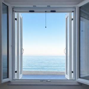 an open window with a view of the ocean at Okio in Petra