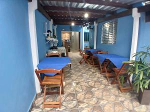 a restaurant with blue walls and wooden tables and chairs at Pousada Milagres de Maria in Aparecida +70 photos