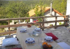 una mesa con tazones y platos de comida en el balcón en Stone House in a quiet landscape, Leonidion, en Leonidio