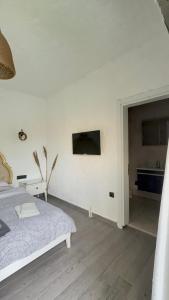 a white bedroom with a bed and a bathroom at Paradise Hotel Alaçatı in Ildır