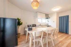 a kitchen and dining room with a table and chairs at 3 Free Rental Bicycles - Free Parking - 85sqm - Up to 9 Guests - 7min to Koreatown - Japanese Lessons by Professional teacher - 自転車3台無料貸出 - 無料駐車場 - 85平米 - 定員9名 - コリアタウン徒歩7分 - Mintak Katsuyama V Residence in Osaka