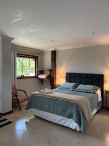 a bedroom with a large bed and a window at Chalé Aconchego da Paz - Chalé 1 in Lavras Novas