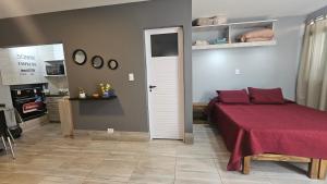 a bedroom with a bed with a red blanket at El Racimo, dpto en Ciudad de Mendoza in Mendoza