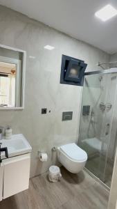 a white bathroom with a shower and a toilet at Paradise Hotel Alaçatı in Ildır +15 photos