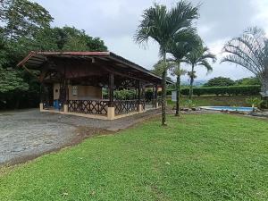 a pavilion in a park with a palm tree at Tucan Apartment in Agua Azul