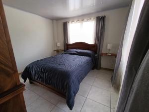 a bedroom with a bed with a blue comforter and a window at Tucan Apartment in Agua Azul +19 photos