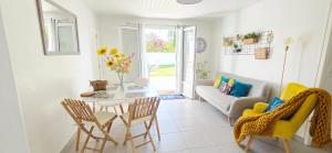a living room with a table and chairs and a couch at Fleur De Cerisier Vendée in Challans