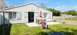 a house with a table and chairs in the yard at Fleur De Cerisier Vendée in Challans +6 photos