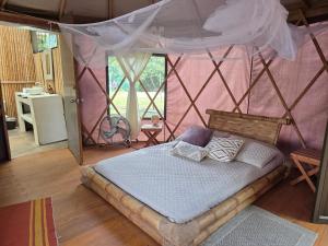 a bedroom with a bed with a mosquito net at Refugio cerca a Villeta in Petaqueros