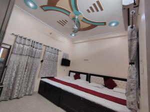 a bedroom with a large bed with a ceiling fan at Shri Sitaram Guest House in Ayodhya