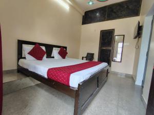 a bedroom with a large bed with red pillows at Shri Sitaram Guest House in Ayodhya