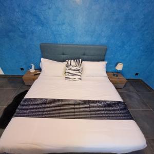 a bedroom with a large bed with a blue wall at Villa burj in Ngaparou
