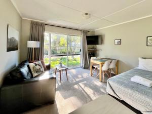 a hotel room with a bed and a table and chairs at Mt Dobson Motel in Kimbell