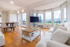 a living room with a white couch and a table at Villa Bista Eder in Hondarribia