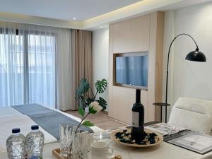 a living room with a television and a table with a lamp at CCLUX Suites - Premium 40sqm Suites near Piraeus Port in Piraeus