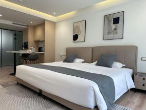 a bedroom with a large white bed and a table at CCLUX Suites - Premium 40sqm Suites near Piraeus Port in Piraeus