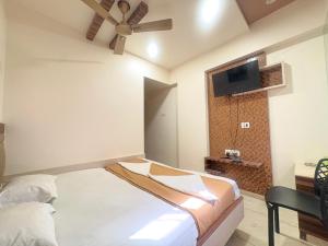 a bedroom with a bed and a ceiling fan at Hotel Falcon Ulhasnagar by Hotelist in Kalyan
