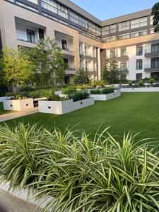a large building with a green lawn in front of it at Embassy Gardens Studio Accra in Accra