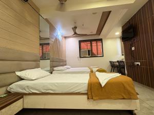 a bedroom with two beds in a room at Hotel Falcon Ulhasnagar by Hotelist in Kalyan