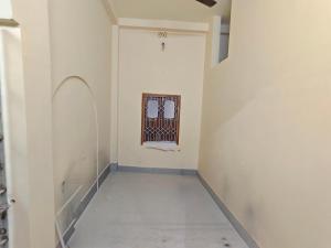 an empty hallway with a gate on the wall at Swapnanir in Howrah