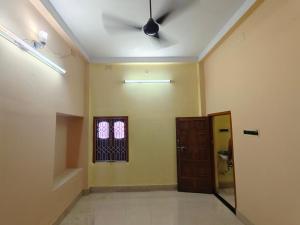 a hallway with a ceiling fan and a door at Swapnanir in Howrah