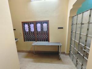 a room with a bench in front of a gate at Swapnanir in Howrah