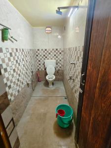 a bathroom with a toilet and a bucket in it at Swapnanir in Howrah