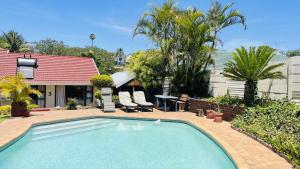 a swimming pool in front of a house at Yolonwabo Bed & Beakfast in East London